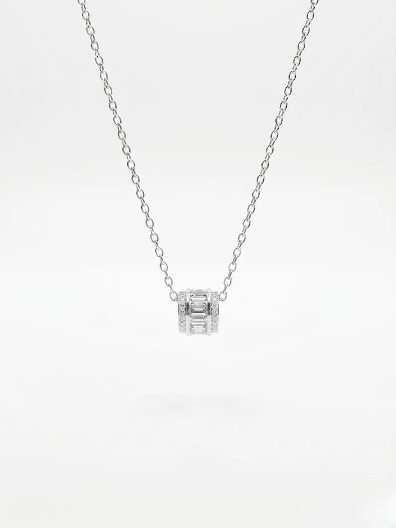 A delicate silver chain necklace with a small box-shaped pendant set with baguette and round-cut clear stones, shown against a plain white background.