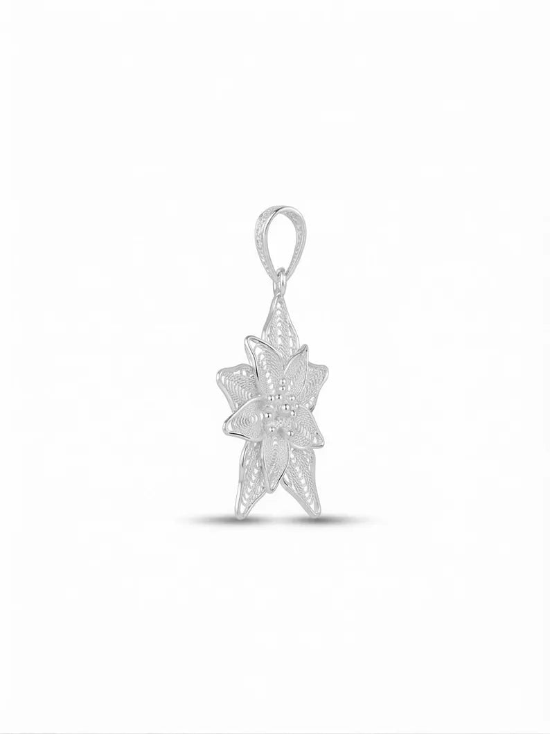 A silver-toned starburst pendant with a textured, openwork design and a top loop, shown on a clean white background.