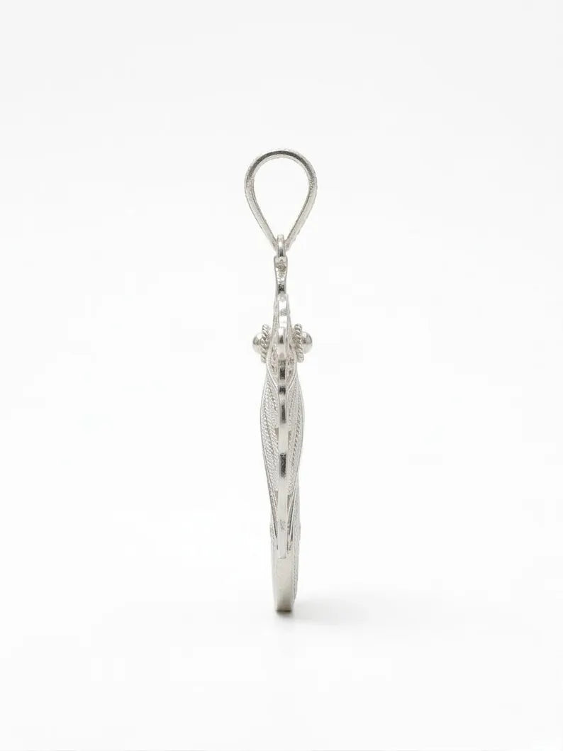 A silver pendant featuring a stylized, vertically oriented snake design with a textured, etched surface and a circular loop at the top, shown against a plain white background.