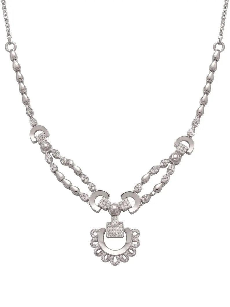 A silver-tone necklace featuring a central horsebit pendant flanked by two curved horsebit links connected by beaded strands of clear stones, set against a plain white background.