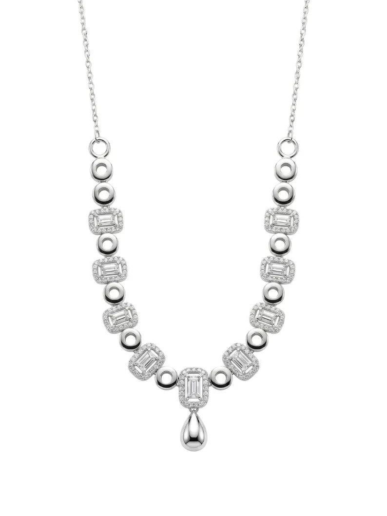 A silver-toned diamond necklace featuring a symmetrical design with baguette and round-cut diamonds, a teardrop-shaped drop center stone, and a delicate chain, shown on a plain white background.