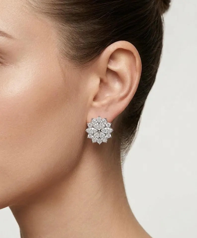 A close-up side profile of a woman wearing a Vintage designer snowflake stud earring set with clear gemstones, against a light gray background.