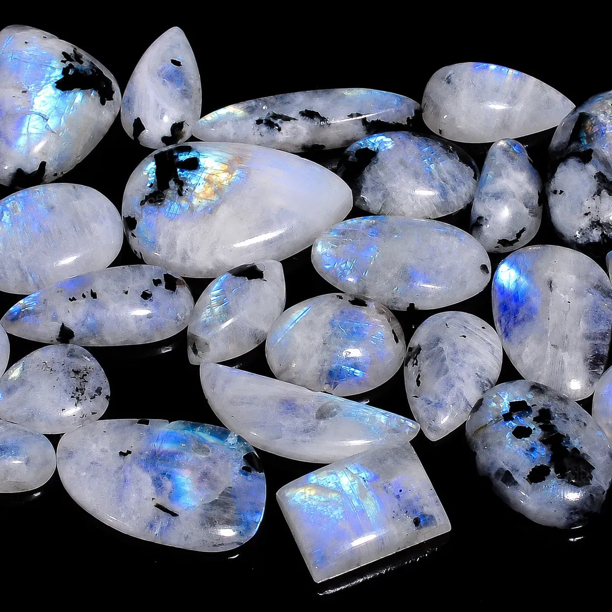Collection of rainbow moonstone cabochons on a black background