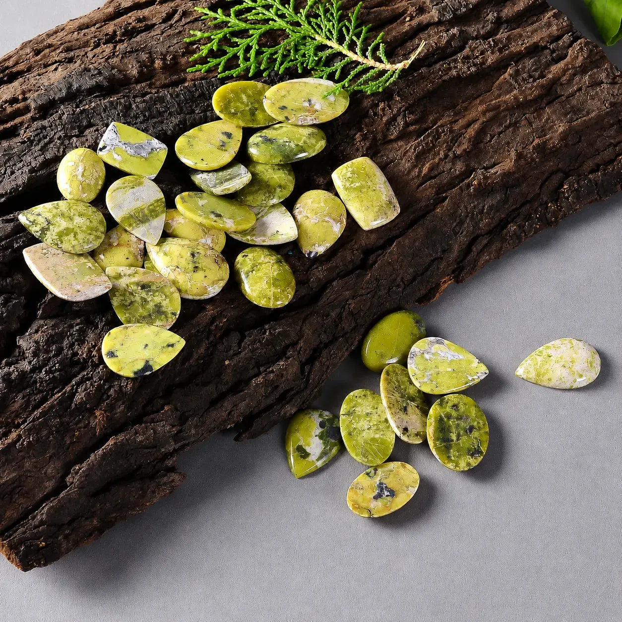 Green and white stone chips on a wooden surface with a gray background