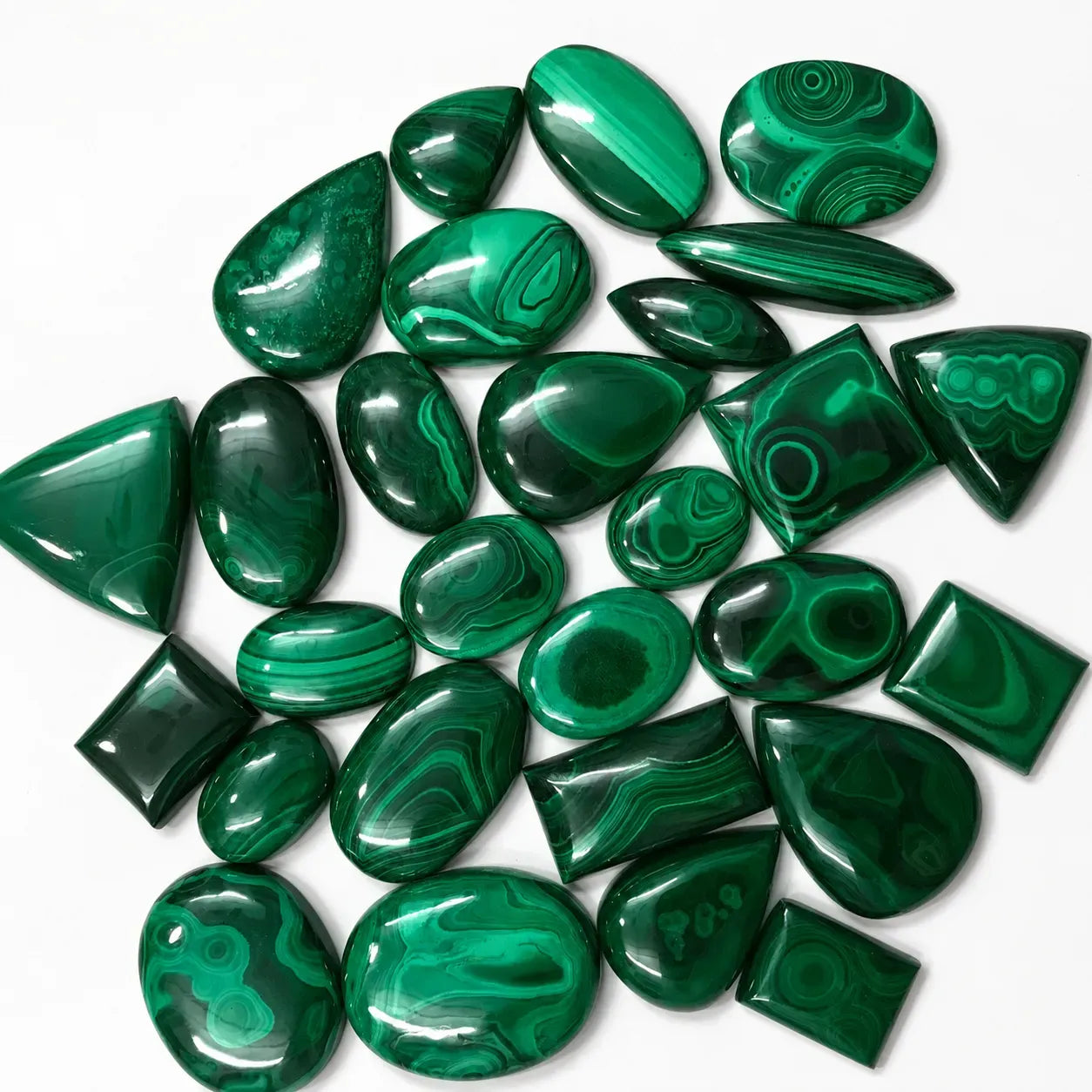Collection of green malachite stones on a white background