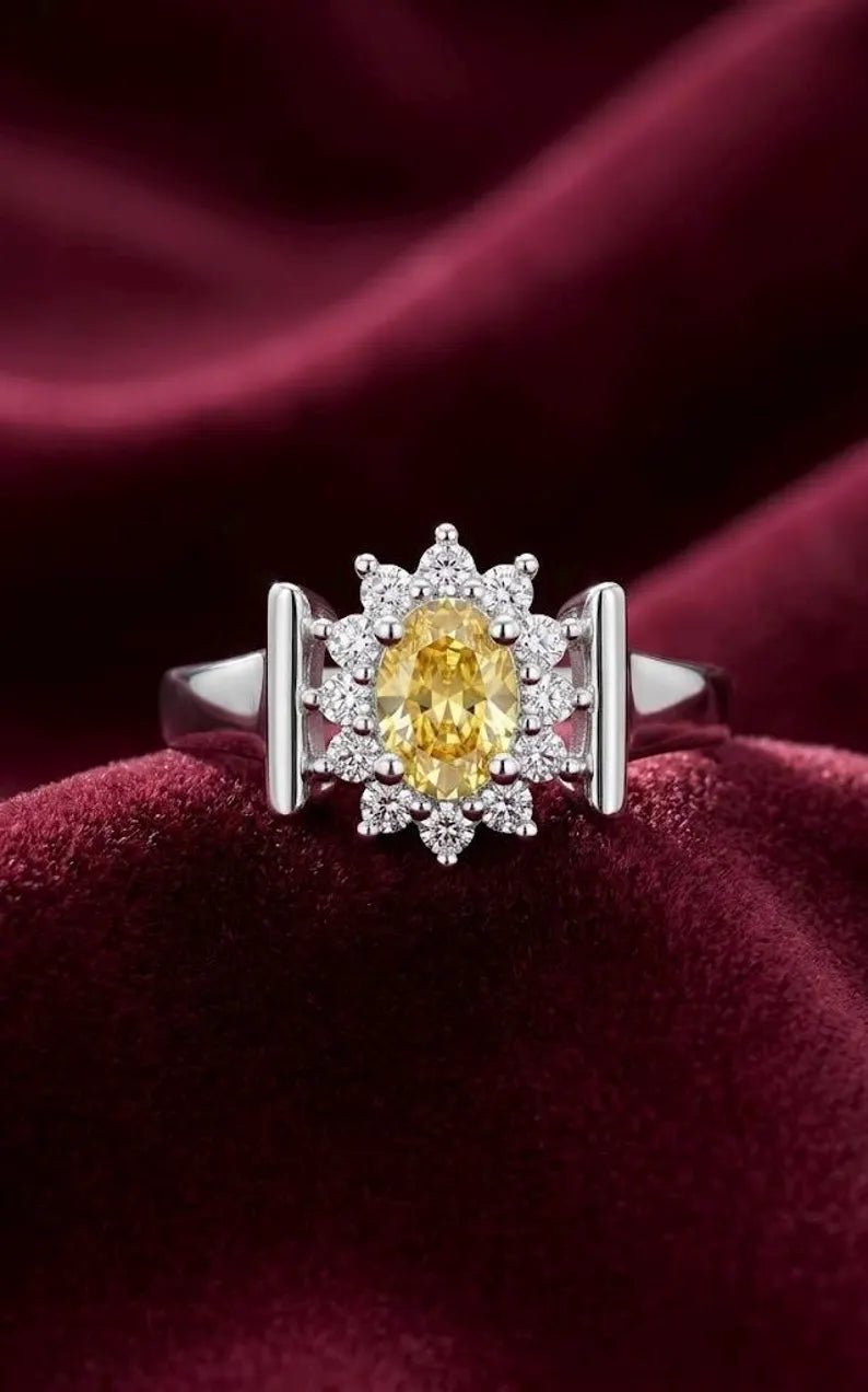 Close up of yellow oval cut CZ statement ring with sunburst halo and bar accent sides